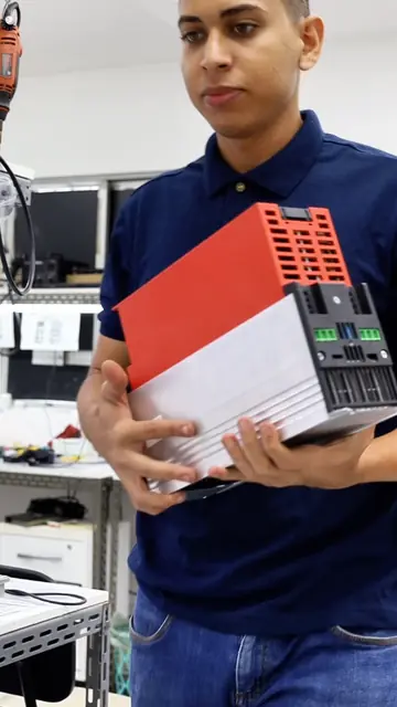 Técnico da Simple Service segurando um inversor de frequência no laboratório