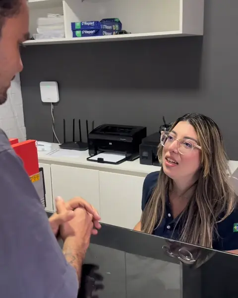 Recepcionista da Simple Service atendendo um cliente no balcão